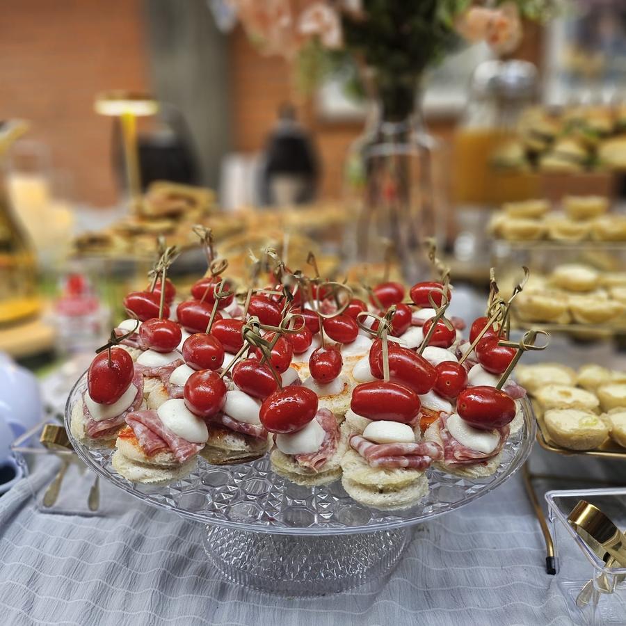 Canapés finos servidos em coffee break de inauguração para convidados em pé