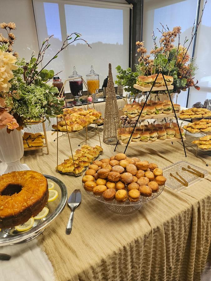 Mesa de coffee break decorada com a identidade visual da marca em um lançamento corporativo