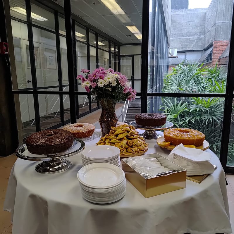 Mesa redonda com bolos junto à janela